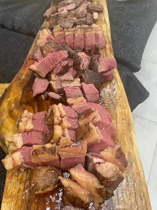 פלטת נתחי בשר צלויים על קרש עץ