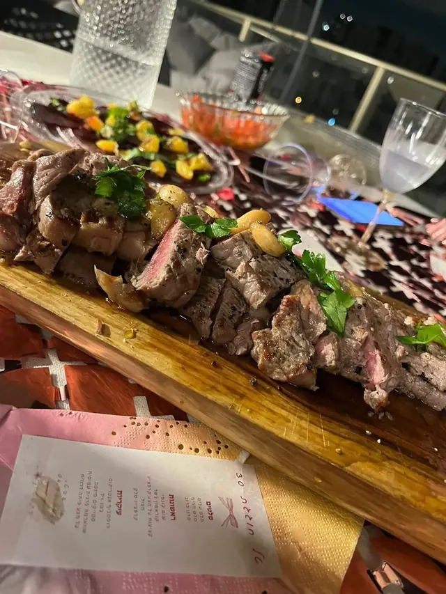 נתחי בשר עם שום קונפי ופטרוזיליה על קרש עץ באירוע ערב